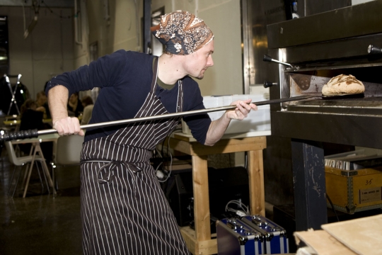 Jérôme putting bread in the oven. Photo: Matti Tanskanen