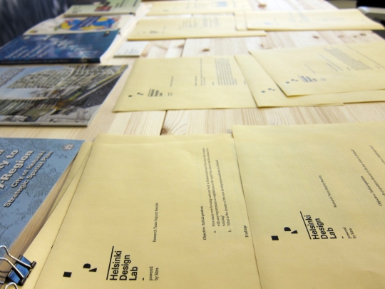 An array of research inquiry memos laid out on the "science lab table" in the studio. Supporting the studio members is a team of three research assistants who track down answers to questions and fix appointments. As the week wore on this table filled up.